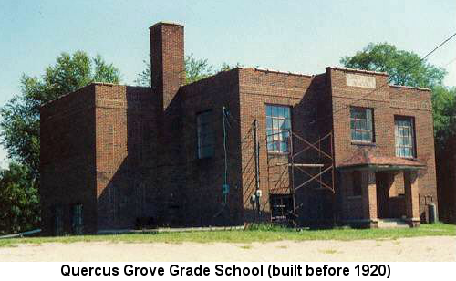 Color photograph of an unused, small, 2-story red brick flat-roofed school building